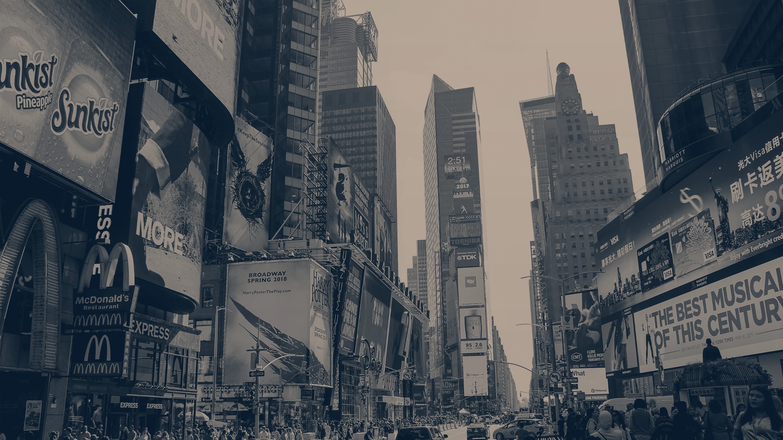 Times Square in New York, walls of billboards climbing every building above a crowded street, in a navy duotone